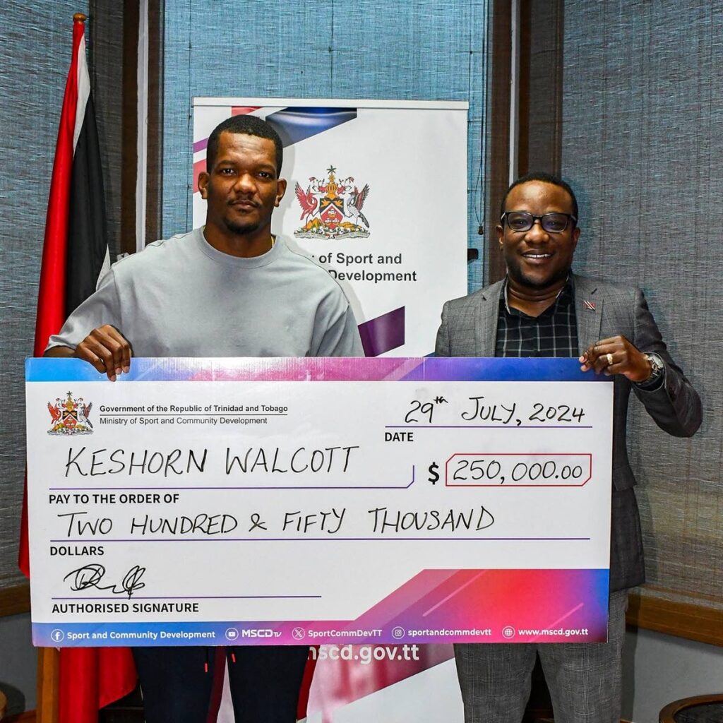 TT javelin star Keshorn Walcott, left, is presented with a $250,000 cheque by acting permanent secretary at the Ministry of Sport and Community Development, David Roberts, at the ministry's head office in Port of Spain on August 12. - Photo courtesy Ministry of Sport and Community Development (Image obtained at newsday.co.tt)