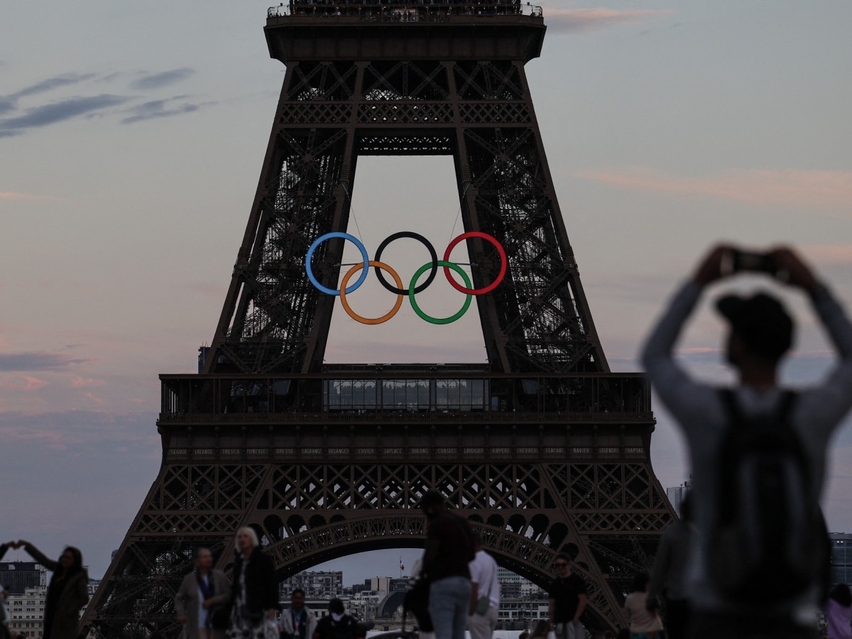 Pedestrians take pictures of the Olympic rings on the Eiffel Tower. GETTY IMAGES (Image obtained at insidethegames.biz)